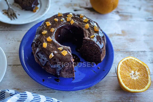 Corte de pastel de paquete de chocolate con azúcar de coco y glaseado de chocolate naranja - foto de stock