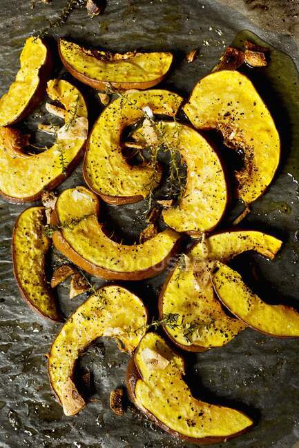 Grilled pumpkin slices with olive oil, garlic and thyme on an oven tray — Stock Photo
