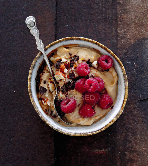 Espresso cream dessert with fresh raspberries and nuts in bowl — Stock Photo