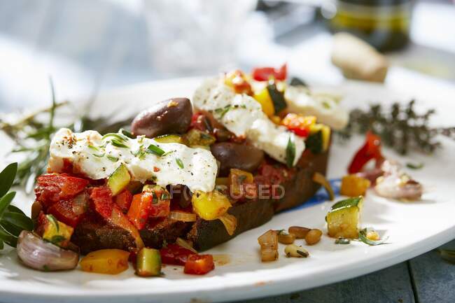 Pão coberto com legumes mediterrâneos e feta — Fotografia de Stock