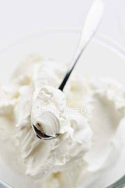 Fresh mascarpone in a glass bowl with a spoon — Stock Photo
