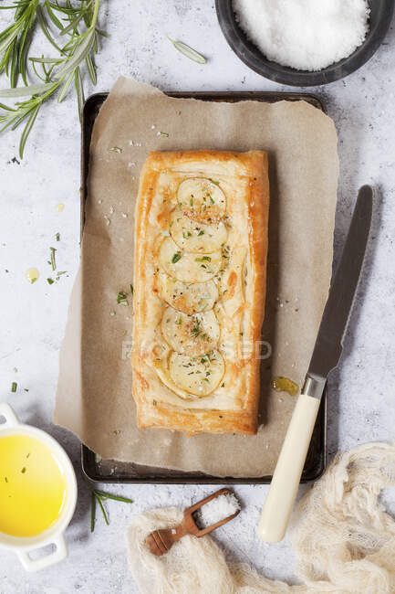 Brie potatoes and rosemary tart on tin with baking paper — Stock Photo