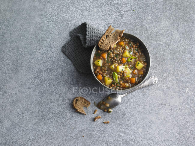 Guisado de lentilha com batatas e cenouras servidas com pão — Fotografia de Stock