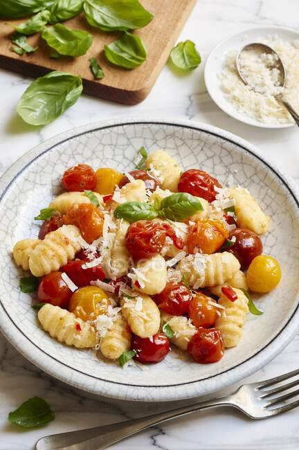 Ньокки с цветными помидорами черри, сыром и базиликом — стоковое фото