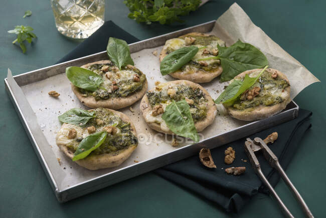 Mini-Dinkelpizzen mit Spinat, veganem Käse und Walnüssen — Stockfoto