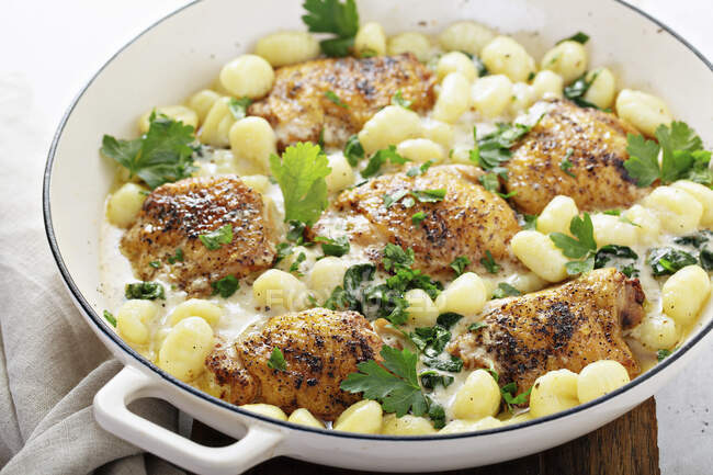 Roasted chicken thighs with gnocchi and spinach — Stock Photo