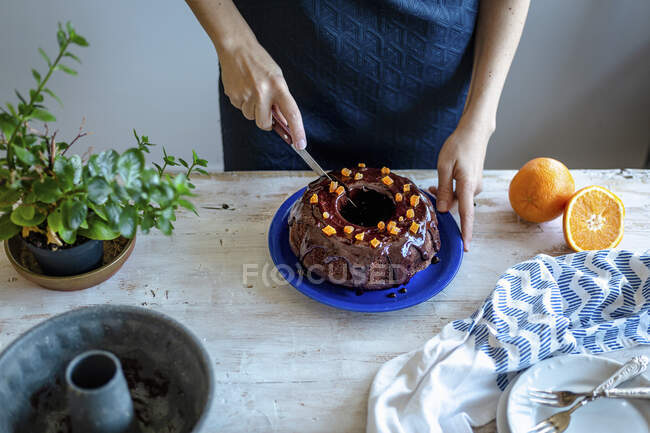 Разрезание шоколадного торта с кокосовым сахаром и апельсиновой глазурью — стоковое фото