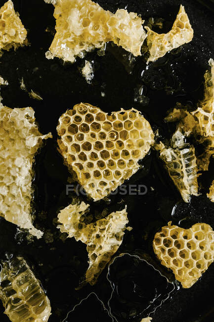 Peine de abeja en forma de corazón sobre fondo negro - foto de stock