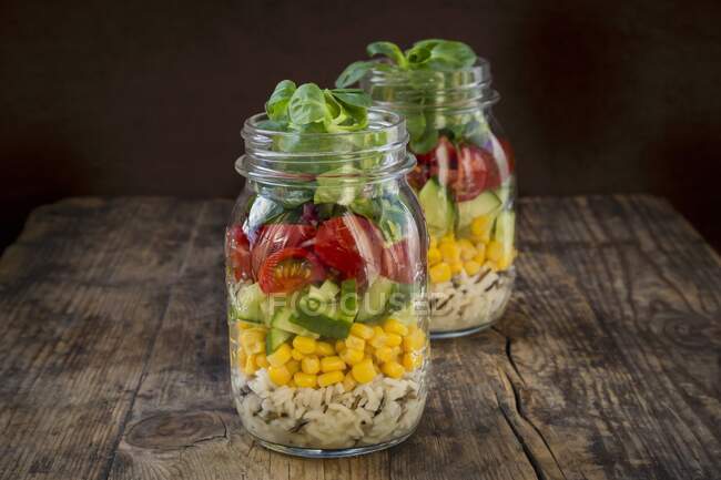 Reissalat im Glas mit Wildreis, Zuckermais, Gurken, Tomaten und Feldsalat — Stockfoto