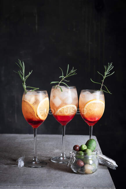 Aperol Spritz im Glas mit Rosmarin und Oliven im Glas — Stockfoto