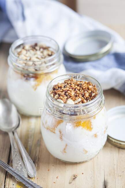 Yogurt with orange pieces and chopped nuts — Stock Photo