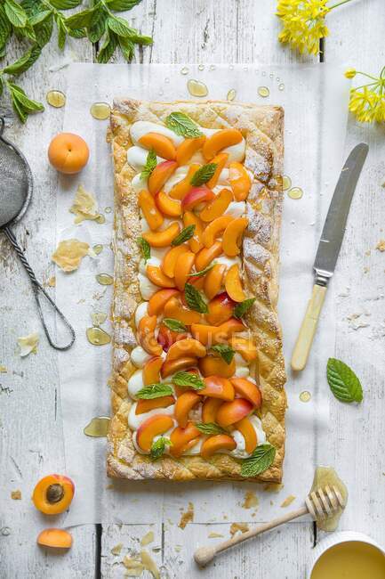 Puff pastry tart with vanilla creame cheese, fresh apricots and honey — Stock Photo