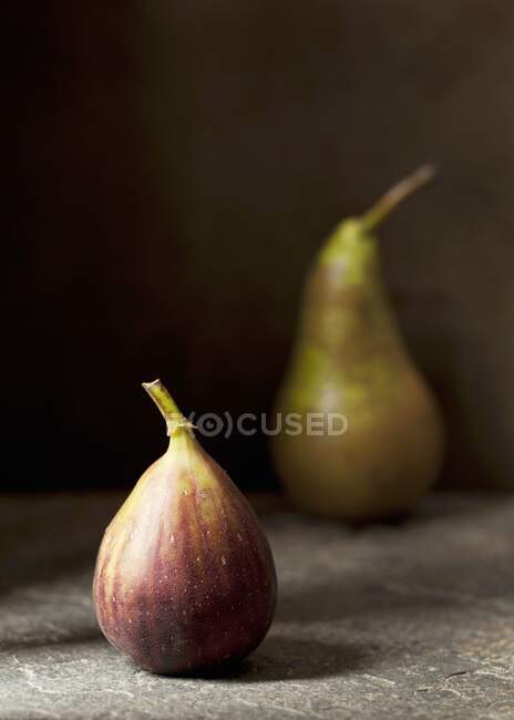 Fresh fig and pear on wooden surface — Stock Photo