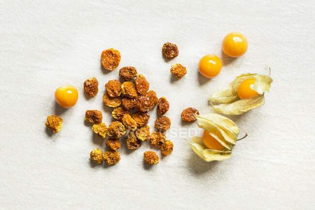 Dried and fresh physalis on a white background (top view) — Stock Photo