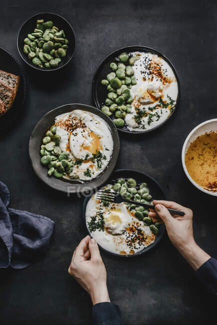 Turkish eggs with broad beans sprinkled with dill and black cumin and slices of bread — Stock Photo