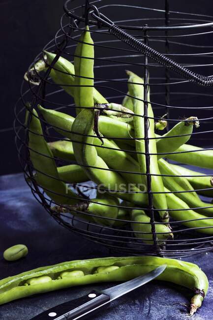 Frijoles verdes en canasta de alambre nostálgico sobre fondo negro - foto de stock