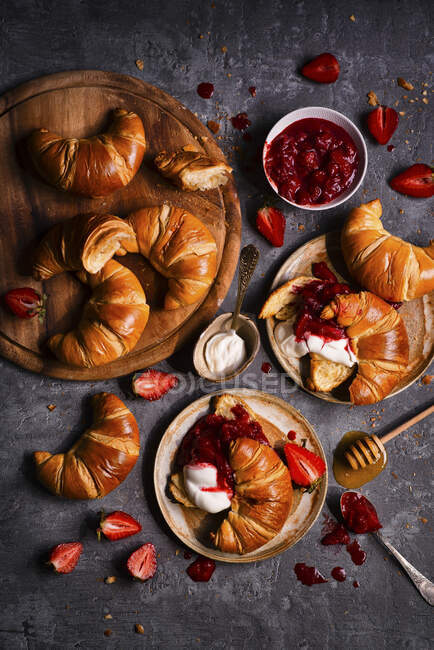 French croissants with yoghurt and strawberry rhubarb jam and honey — Stock Photo
