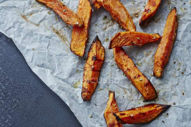 Sweet potato fries on baking paper — Stock Photo