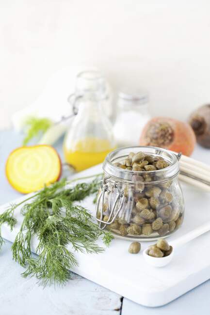 A jar of capers with dill — Stock Photo