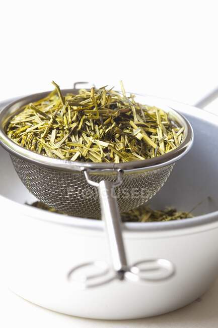 Japanese Kukicha tea in a strainer and a bowl — Stock Photo