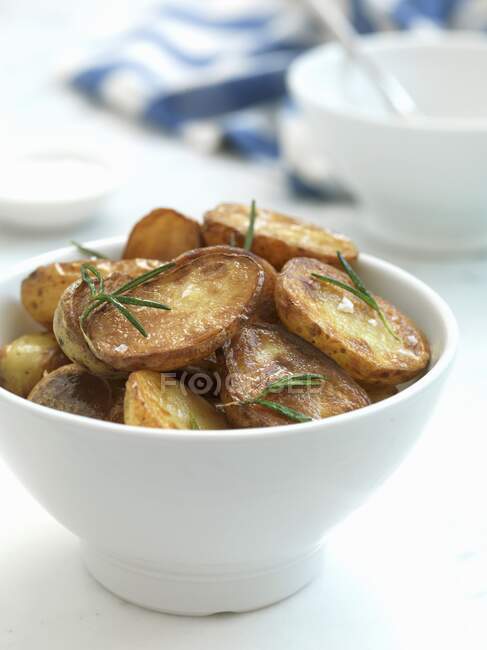 Baked Potatoes with rosemary in small bowl — Stock Photo