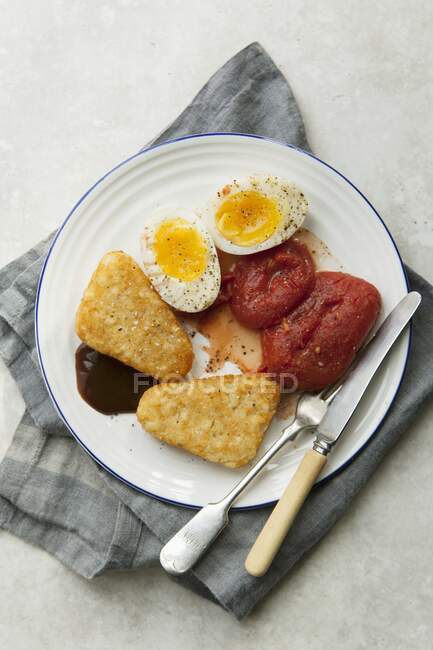 Vegetarian English breakfast with hash browns, tomatoes and eggs - foto de stock