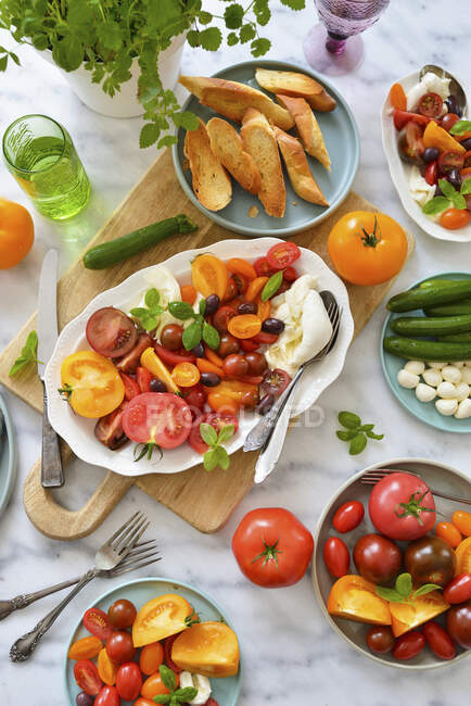 Tomatoes with mozzarella, burrata, kalamata olives, and croutons. Italian dinner — Stock Photo