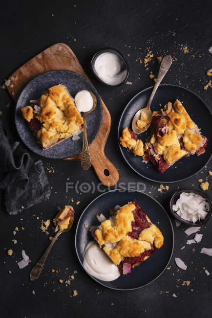 Portions of shortbread with coconut plums and crumble served with natural yogurt — Stock Photo