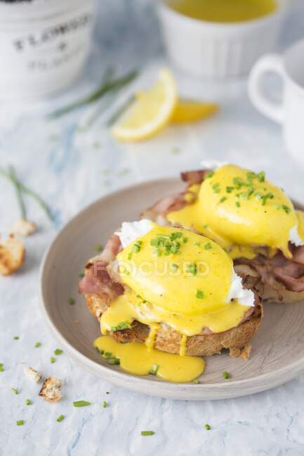 Poached eggs with crispy bacon and hollandaise sauce on toasted bread — Stock Photo