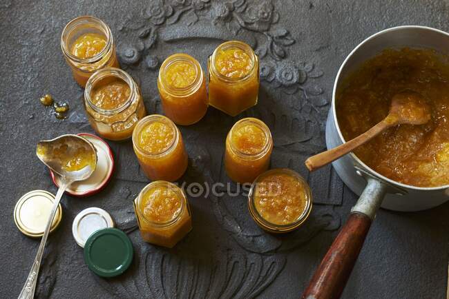 Mermelada de mandarina en una cacerola y frascos de vidrio - foto de stock