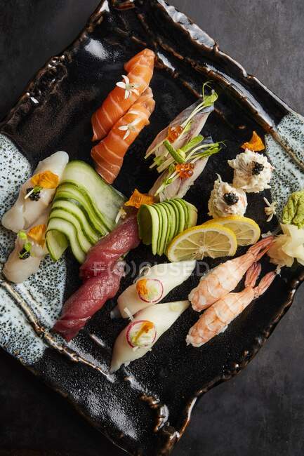Un plato de sushi con pepinos - foto de stock