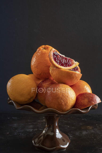 Апельсини та кров'яні апельсини в керамічній мисці — стокове фото