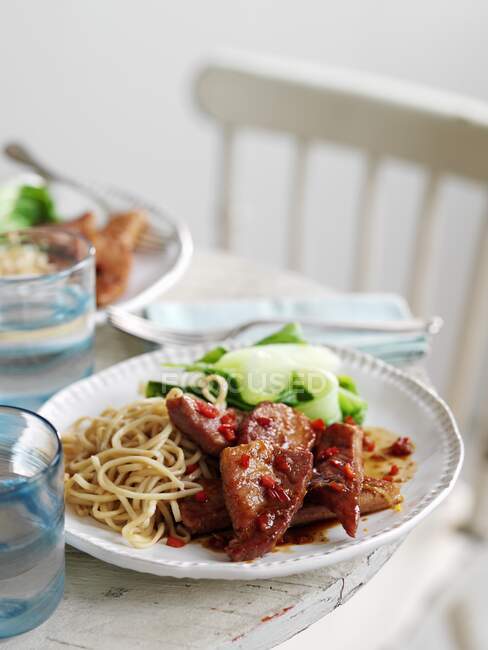 Sticky gammon steaks with noodles and salad — Stock Photo