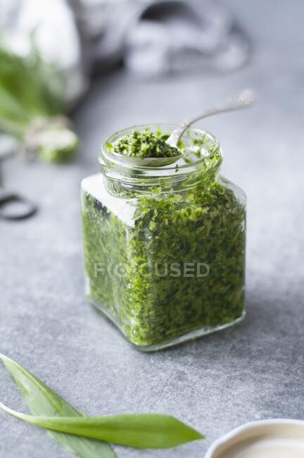 Зелений соус песто в скляній банці на столі — стокове фото