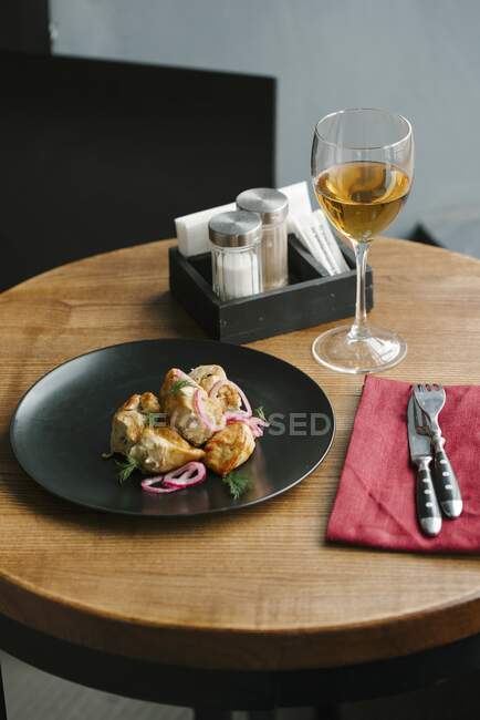 Chicken pieces of skewers with red onions and dill on black plate — Stock Photo