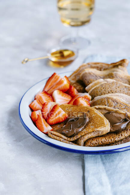 Cinnamon crepes with nutella and fresh strawberries — Stock Photo