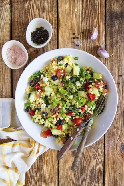 Salad with couscous, olives, tomatoes, cucumber and feta cheese — Stock Photo
