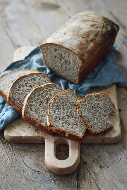 Fette di pane integrale con panno blu su tavola di legno — Foto stock