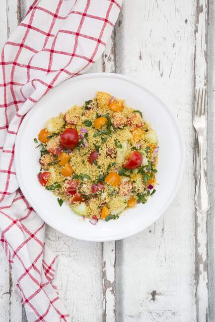Couscous with colourful tomatoes, parsley, cucumber and red onion — Stock Photo