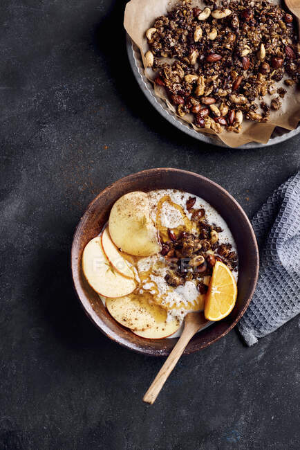 Миска для сніданку з йогуртом, яблуком, апельсином, гранолою, медом та корицею — стокове фото