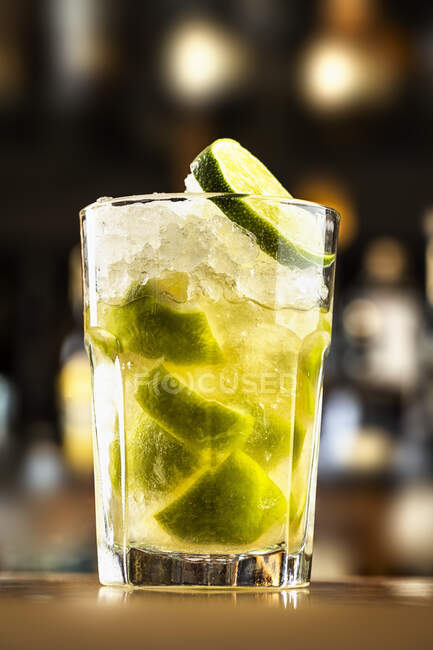 Ein Cocktail mit zerstoßenem Eis und Limettenscheiben im Glas — Stockfoto