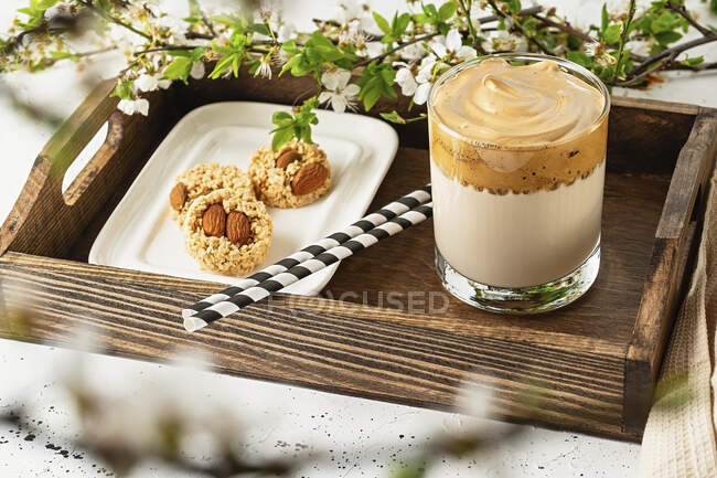 Dalgona coffee with cookies on a wooden tray — Stock Photo