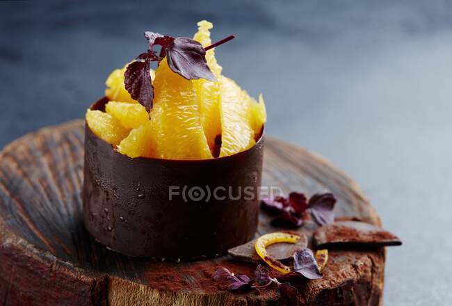 Primer plano de deliciosos filetes de naranja en una taza de chocolate - foto de stock
