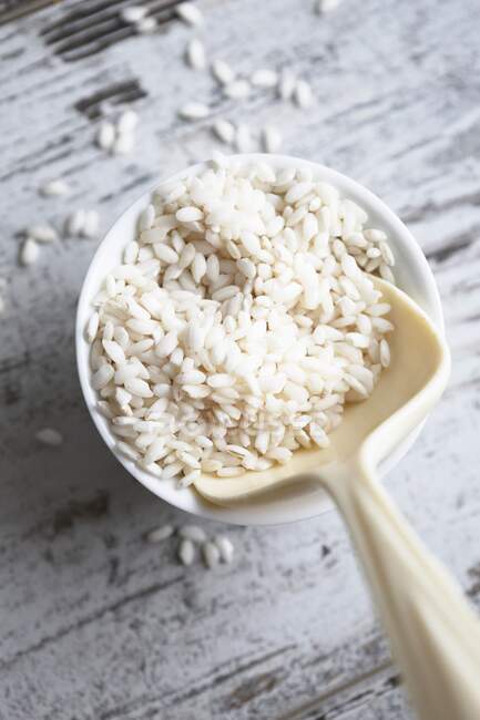Round-grain rice in a bowl with a spoon (seen from above) — Stock Photo