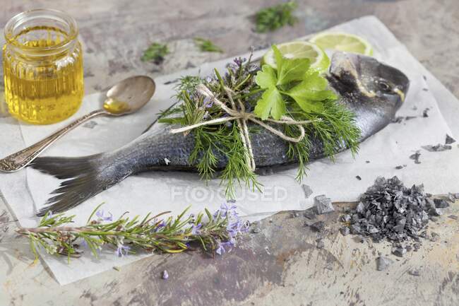 Fresh gilthead seabream with herbs and lime slices — Stock Photo