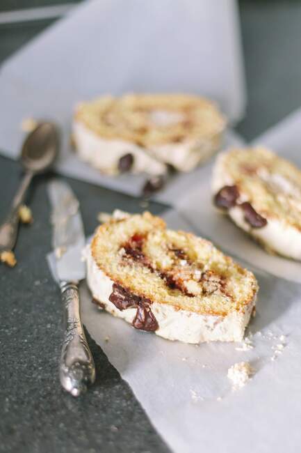 Biscuity roll with fruit and chocolate filling on a white parchment — Stock Photo