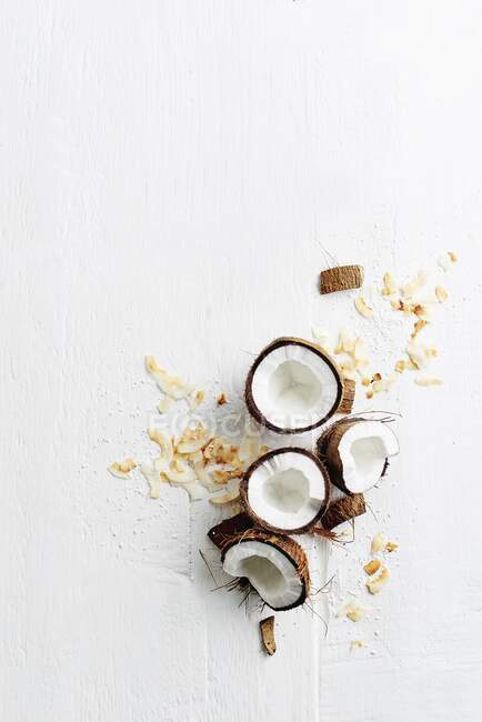 An arrangement of fresh coconuts and dried coconut shavings (seen from above) — Stock Photo