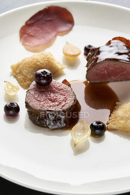 Saddle of venison with potato turnovers and blueberries — Stock Photo