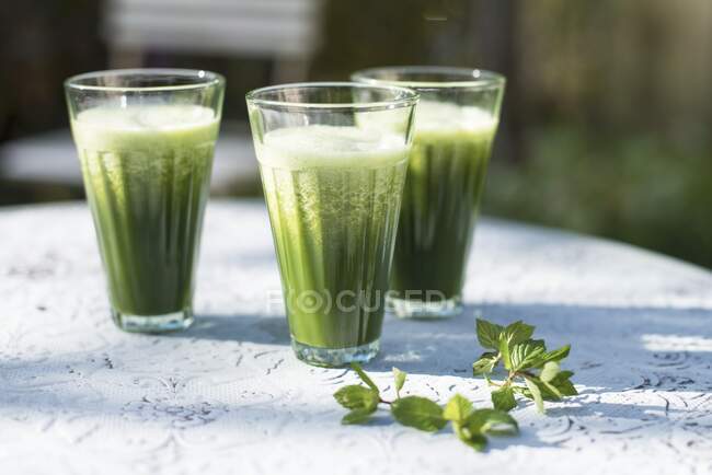 Lime cocktails with wheatgrass powder in sunlight — Stock Photo