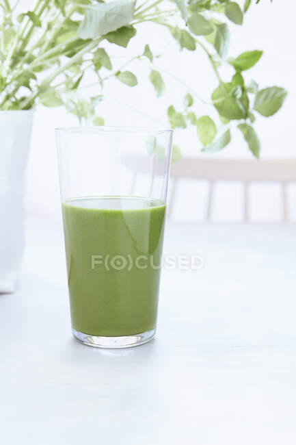 Succo verde fresco con foglie sul tavolo di legno. — Foto stock
